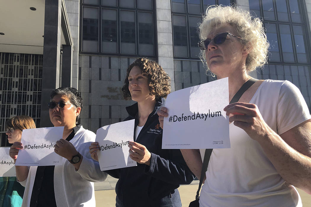 Protestors hold signs that read "Defend Asylum" outside of the San Francisco Federal ...