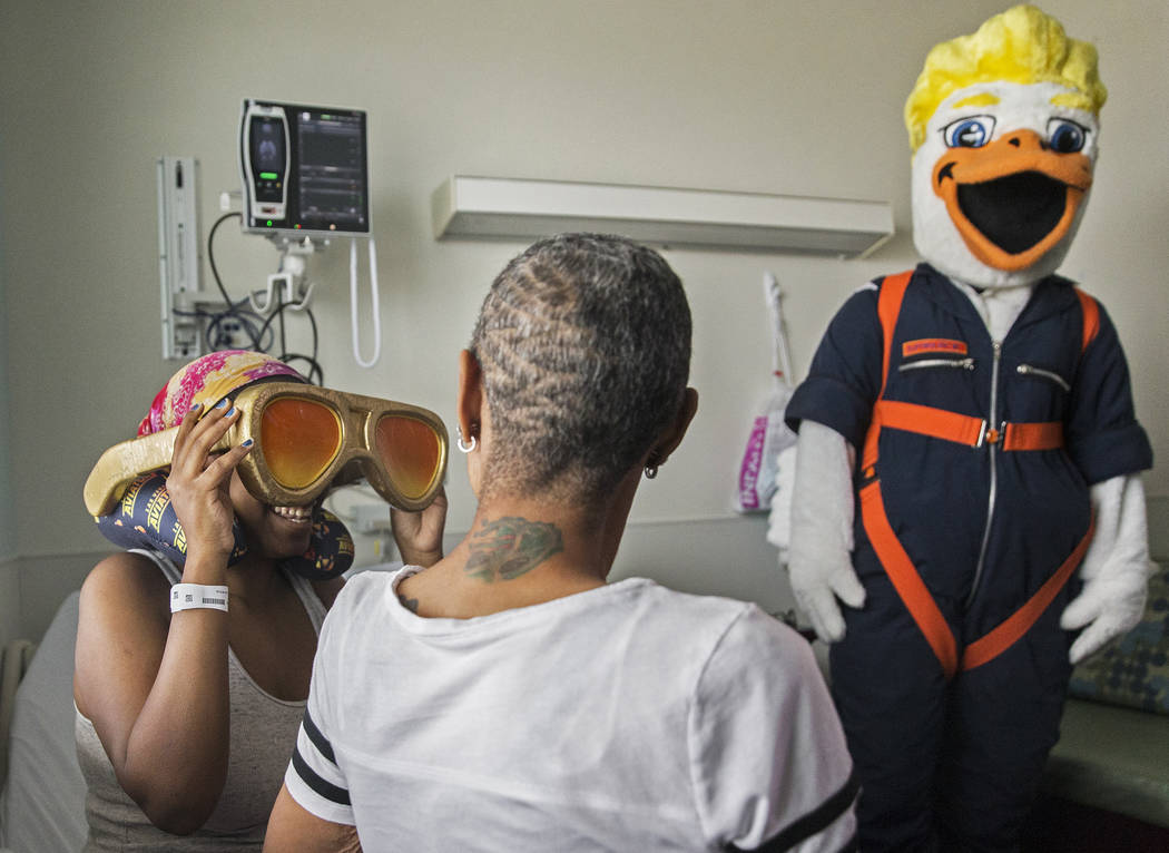 Bryanna Duggans, left, tries on Las Vegas Aviators mascot Spruce the Goose's sun glasses at Chi ...