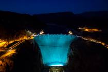 Hoover Dam, lit up turquoise to promote lung cancer awareness, as seen from O'Callaghan-Tillman ...
