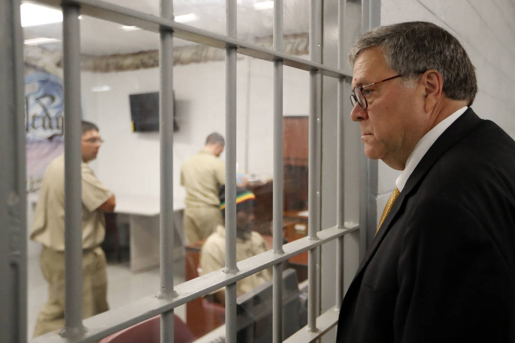 Attorney General William Barr watches as inmates work in a computer class during a tour of a fe ...