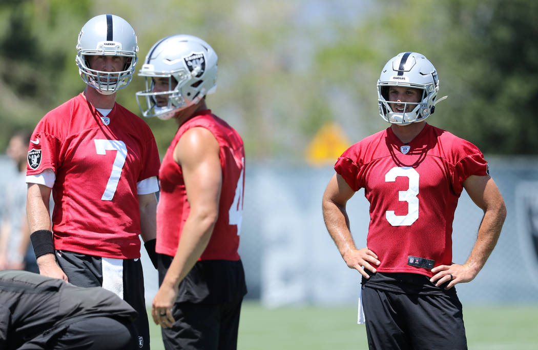 Oakland Raiders quarterbacks Mike Glennon (7) and Nathan Peterman (3) watch Derek Carr (4) run ...