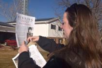 In this December 2018 photo, a victims advocate in Greeley, Colo. posts a flyer of a missing pe ...
