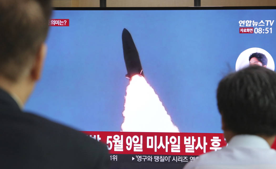 People watch a TV showing a file image of North Korea's missile launch during a news program at ...