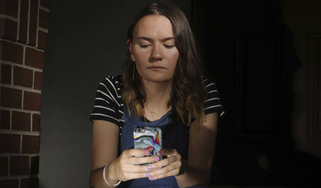 In this Monday, July 22, 2019 photo, Rachel Whalen looks at her phone at her home in Draper, Ut ...