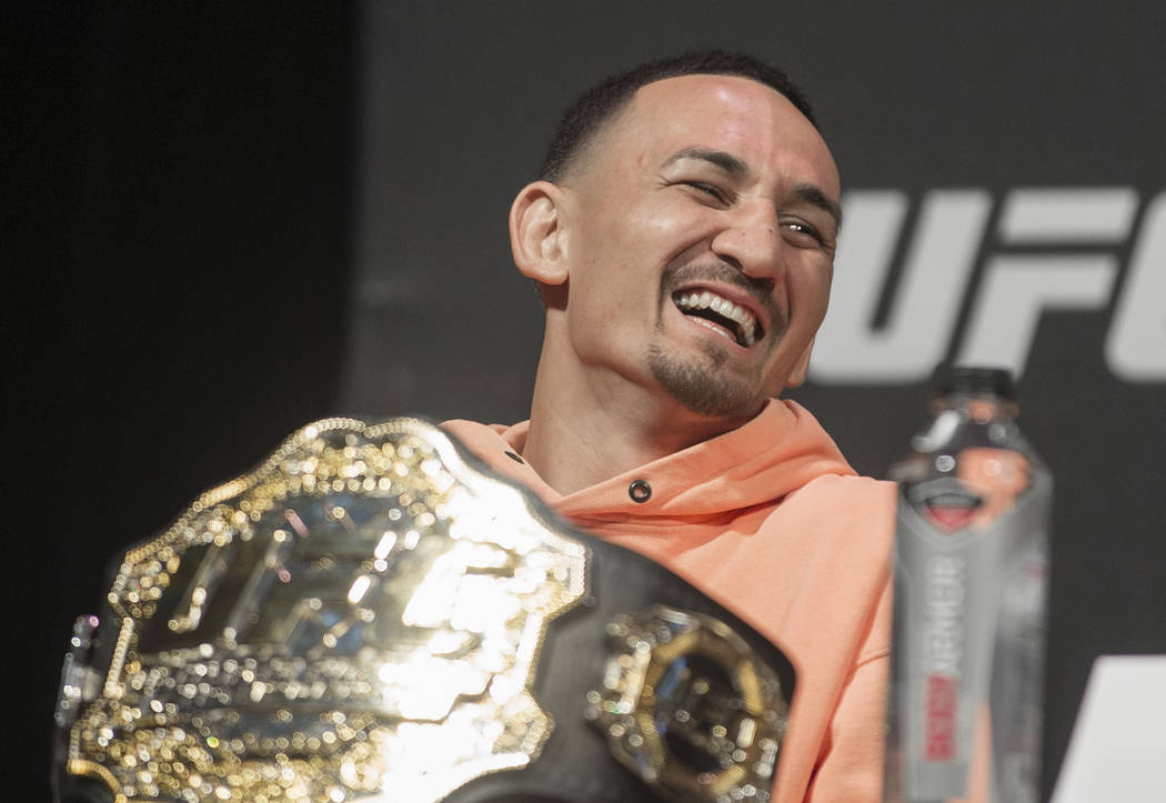 UFC featherweight champion Max Holloway shares a laugh with fellow fighters during a press conf ...