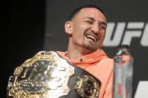 UFC featherweight champion Max Holloway shares a laugh with fellow fighters during a press conf ...