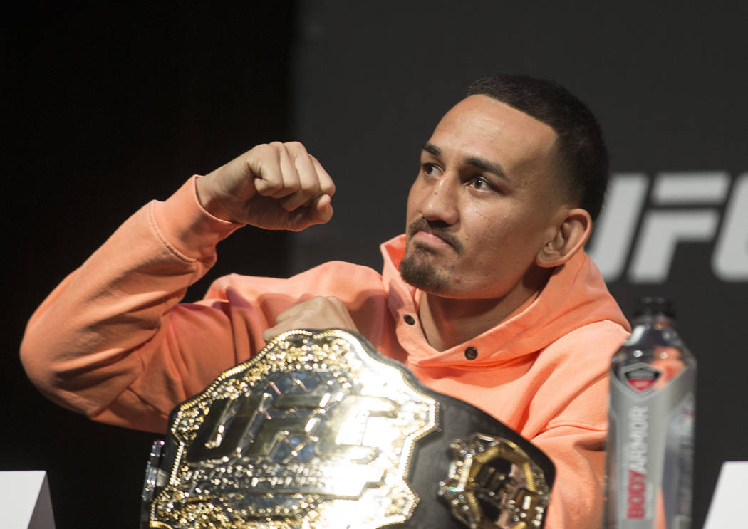 UFC featherweight champion Max Holloway pumps his fist to the crowd during a press conference o ...
