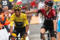 Britain's Geraint Thomas, right, congratulates Colombia's Egan Bernal wearing the overall leade ...