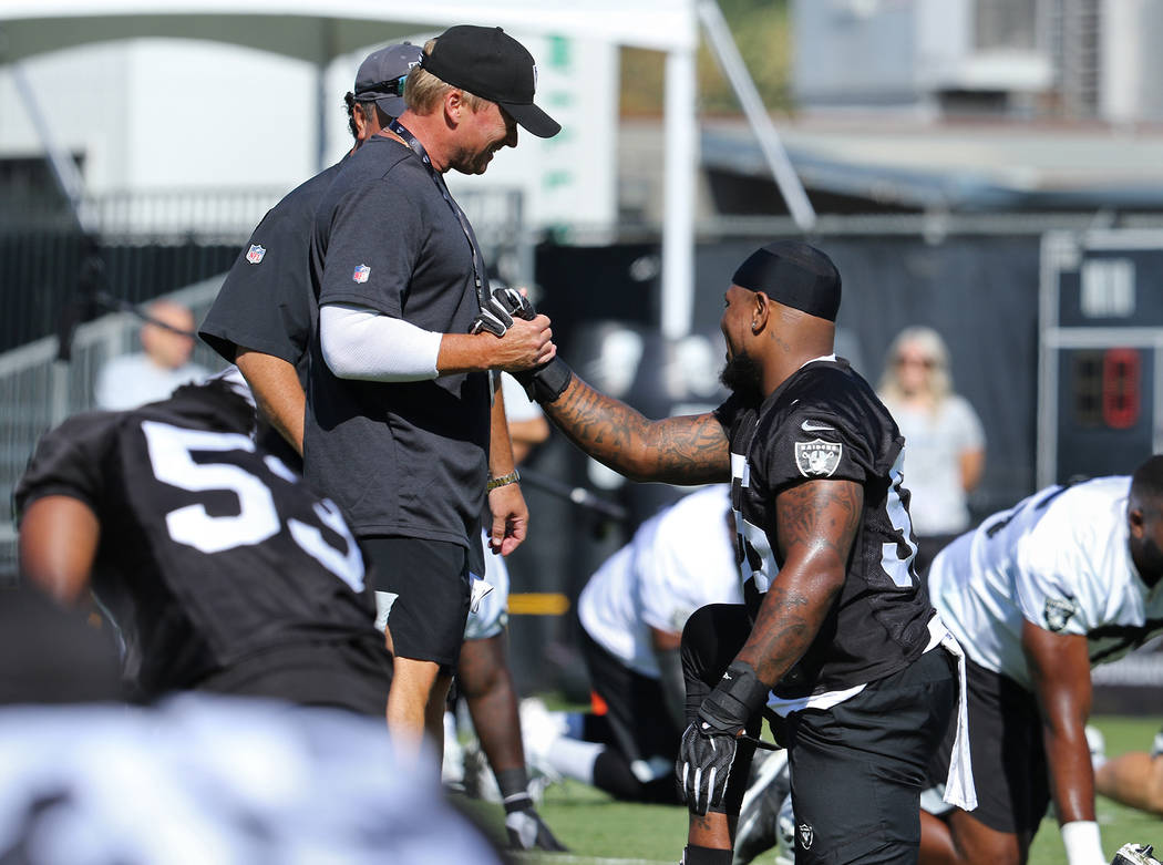 Oakland Raiders head coach Jon Gruden, left, shakes hands with linebacker Vontaze Burfict (55) ...