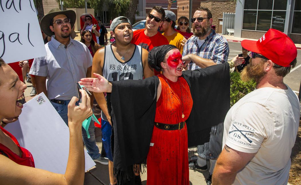 Melissa Akiima Eggstaff, middle, of Red Rage Protest for Kids in Cages, blocks her group from c ...