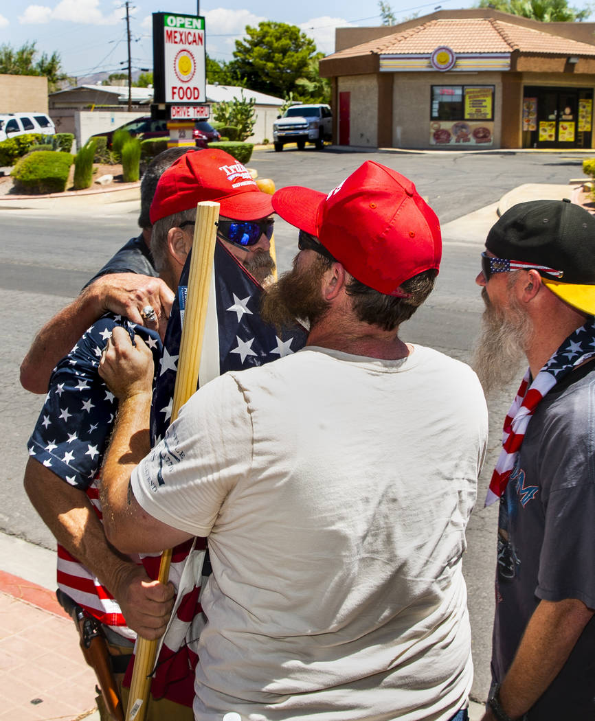 Counter protester John Eakins, left, is restrained by others after confronting protesters with ...