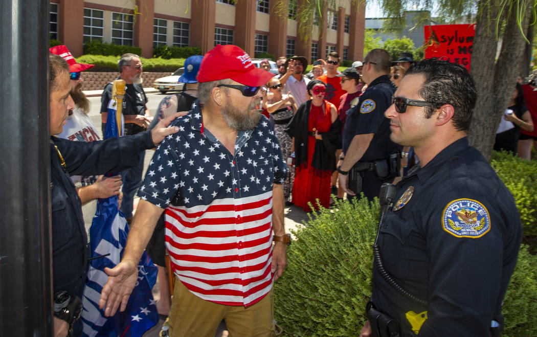 Counter protester John Eakins, left, talks with Henderson Police officers after confronting pro ...