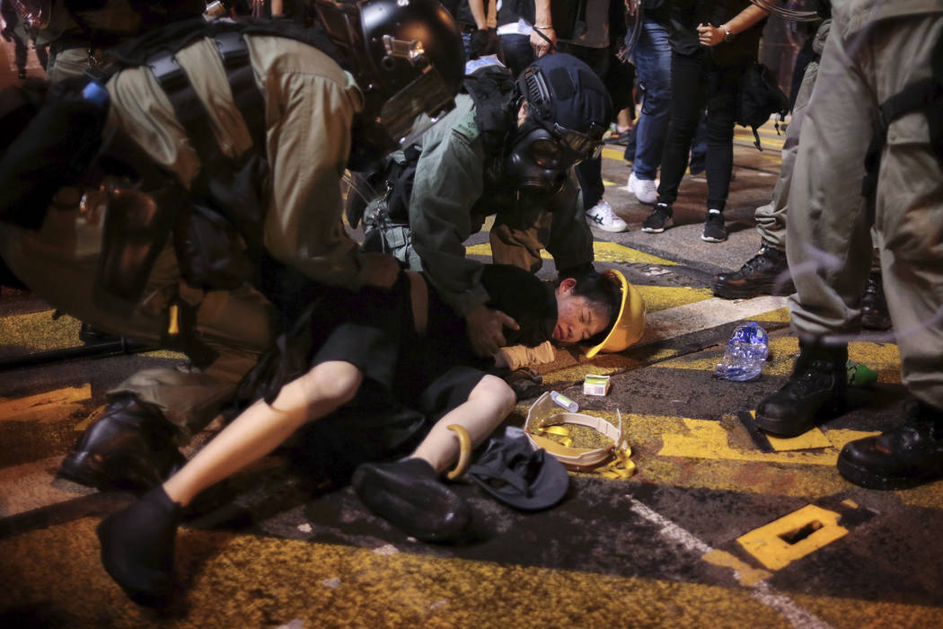 Hong Kong police officers detain a protester on the streets of Hong Kong on Sunday, July 28, 20 ...