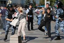 Police officers detain people during an unsanctioned rally in the center of Moscow, Russia, Sat ...