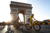 Colombia's Egan Bernal wearing the overall leader's yellow jersey, center, rides past the Arc d ...