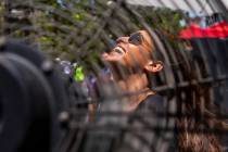 Sapir Partush from Israel cools off from the heat in a fan outside of the L'Core Paris beauty s ...