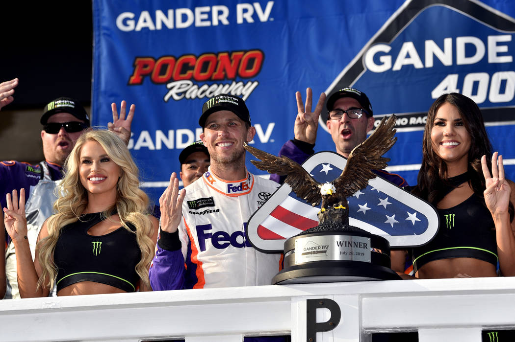 Denny Hamlin, front center, celebrates in Victory Lane after winning a NASCAR Cup Series auto r ...