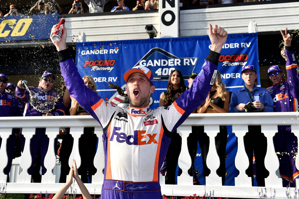 Denny Hamlin celebrates in Victory Lane after winning a NASCAR Cup Series auto race, Sunday, Ju ...