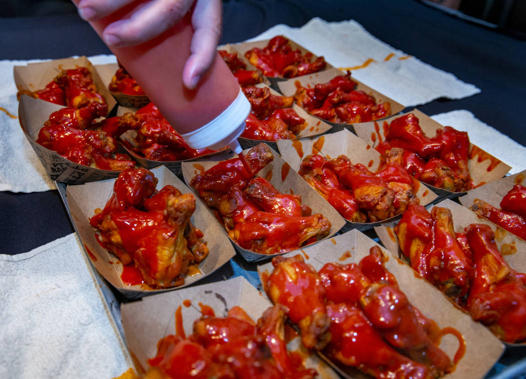 More sauce is poured on a new batch of wings as PT's Ranch hosts a $4,000 wing-eating challenge ...