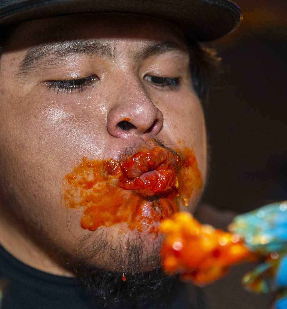 Competitor Alejandro Pascacio feels the sauce burn while eyeing another wing as PT's Ranch host ...