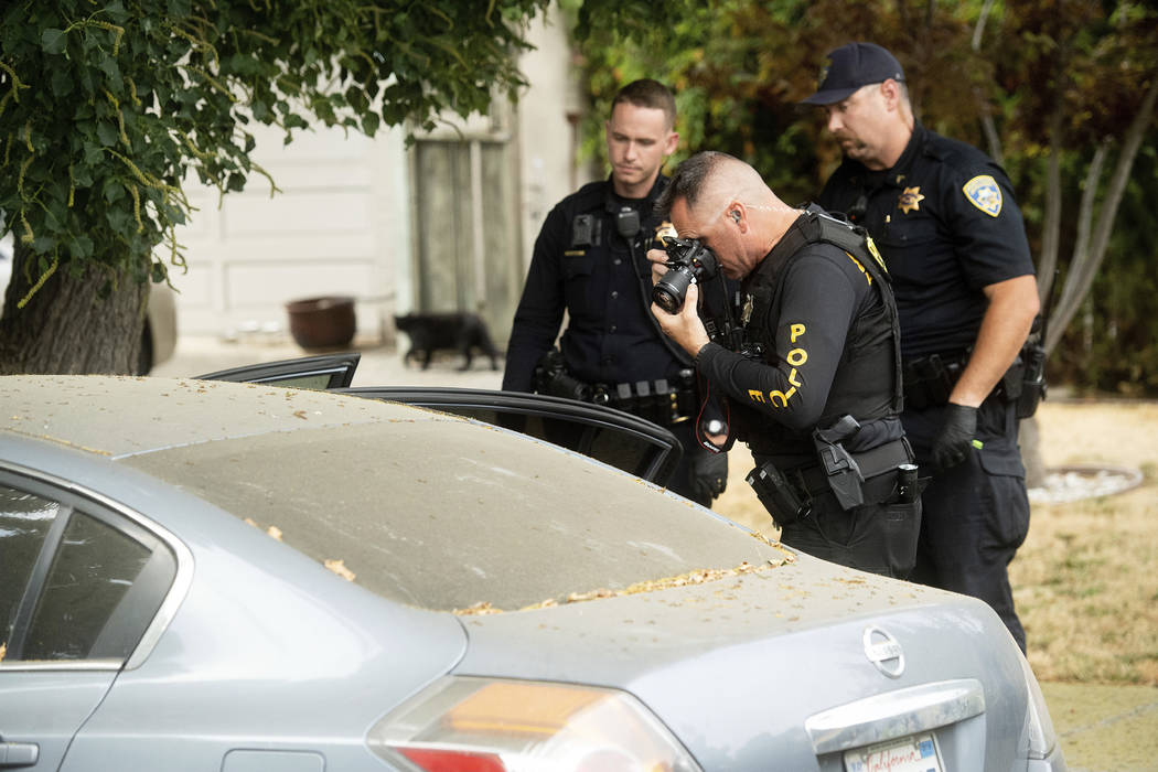 A police officer photographs a car outside the family home of Gilroy Garlic Festival gunman San ...
