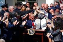 President Donald Trump holds up the signed H.R. 1327 bill, an act ensuring that a victims' comp ...
