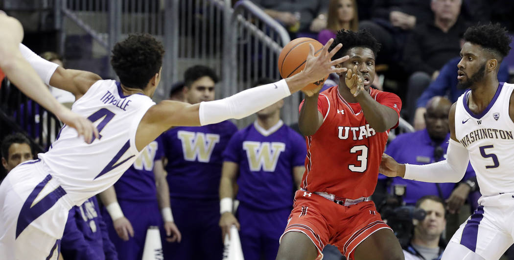 Washington's Matisse Thybulle (4) stretches across to try to stop a pass from Utah's Donnie Til ...