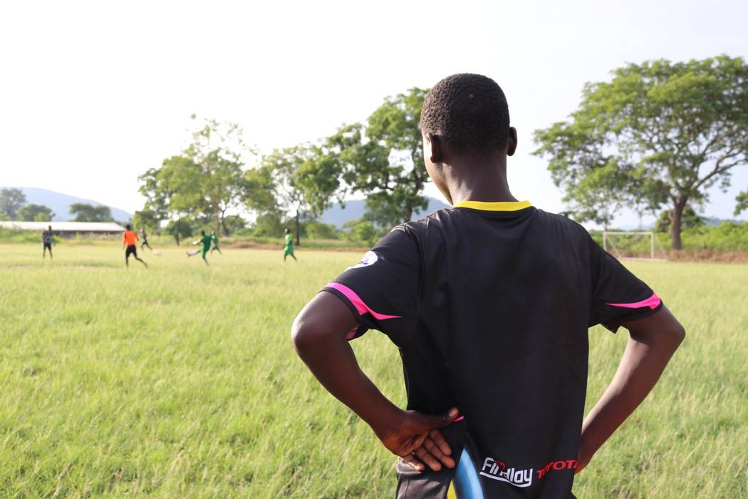 A young man waits to sub into a local town soccer match from the Vima Orphanage in Tsibu-Bethel ...
