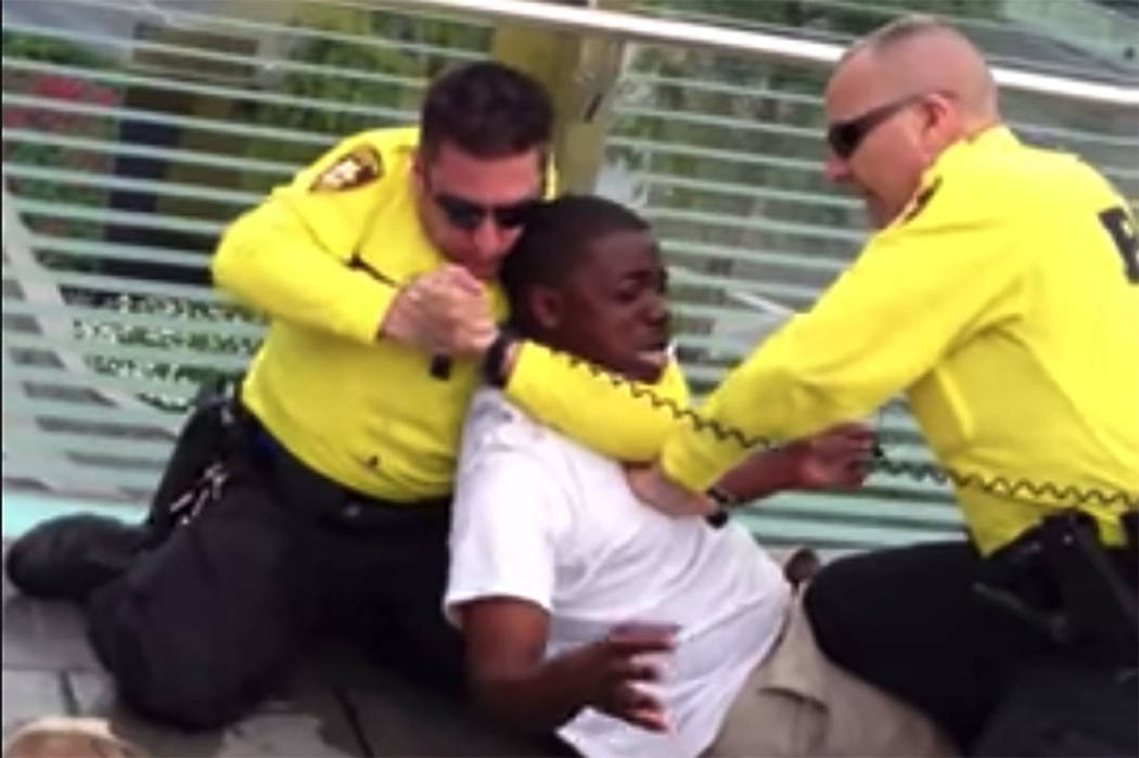 A screenshot from a 2013 video shows 2 Las Vegas police officers apprehending a man on the Las ...