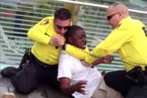 A screenshot from a 2013 video shows two Las Vegas police officers apprehending a man on the La ...
