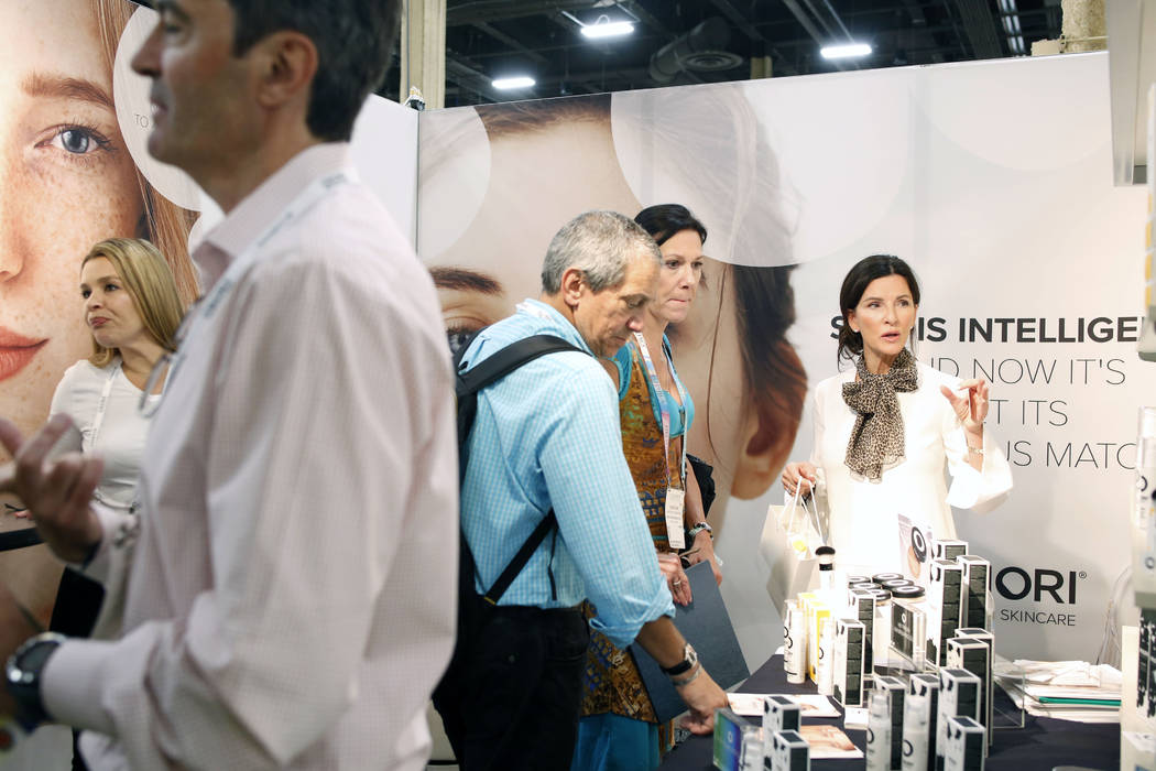 Individuals inquire about Priori Skincare products at Cosmoprof North America at the Mandalay B ...