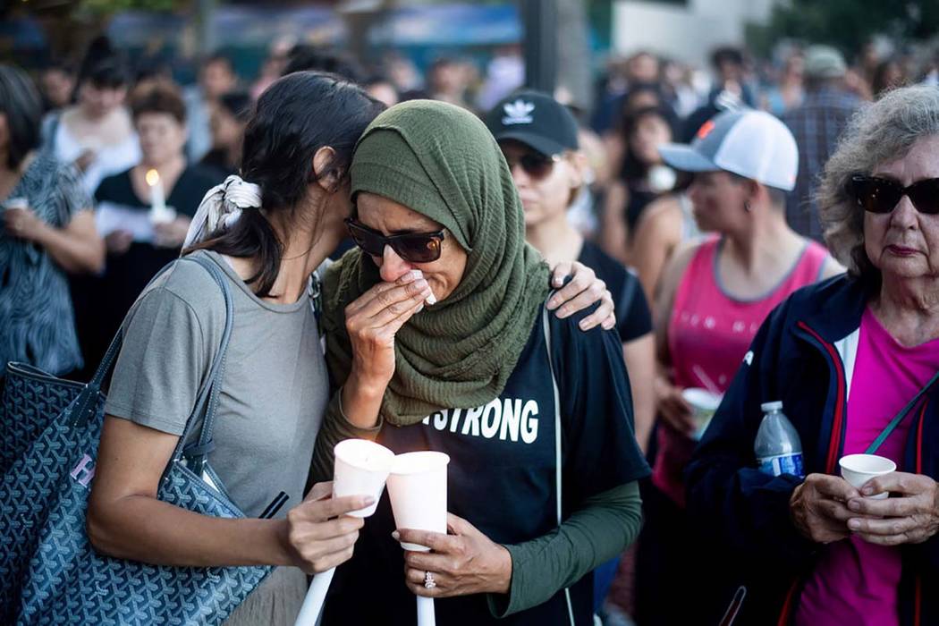 Hina Moheyuddin, left, comforts Noshaba Afzal during a vigil for victims of a Sunday evening sh ...