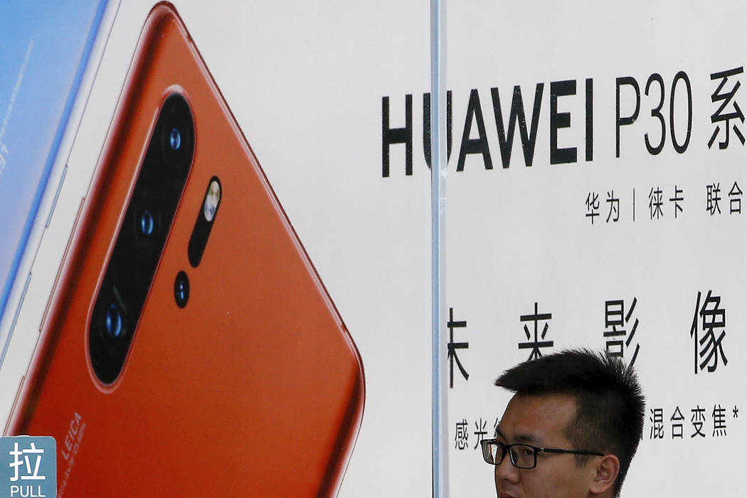 A staffer looks out from a Huawei retail store in Beijing, Tuesday, July 30, 2019. Huawei's glo ...