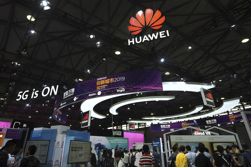 In this June 27, 2019, photo, visitors tour the Huawei pavilion at the Mobile World Congress in ...