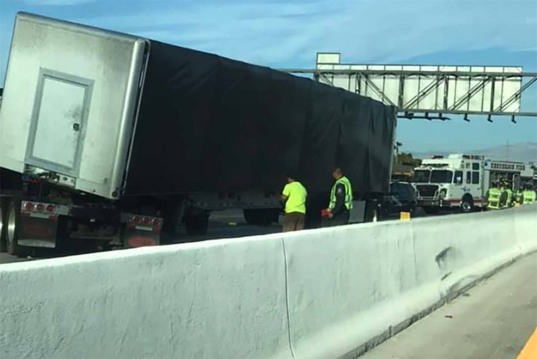 Workers inspect a semi involved in a crash at Interstate 215 and Gibson Road on Tuesday, July 3 ...