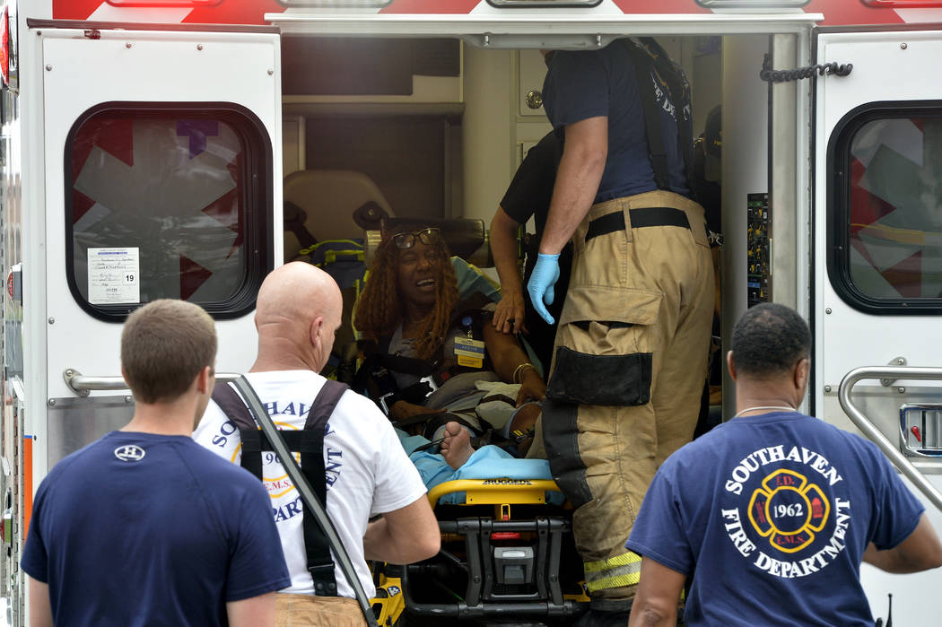 A Walmart employee receives medical attention after a shooting at the store, Tuesday, July 30, ...