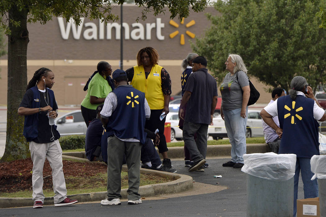 Employees gather in a nearby parking lot after a shooting at a Walmart store Tuesday, July 30, ...