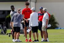 New Orleans Saints head coach Sean Payton, left with back facing camera, greets NBA basketball ...