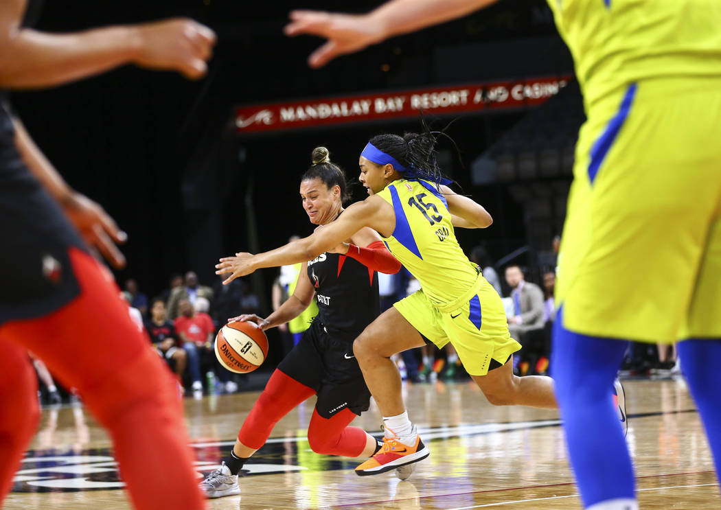 Las Vegas Aces' Kayla McBride (21) drives the ball under pressure from Dallas Wings' Allisha Gr ...