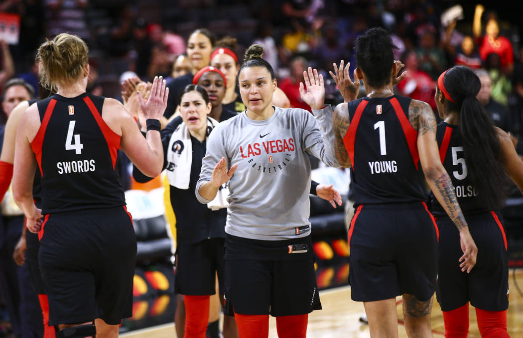 Las Vegas Aces' Kayla McBride, center, celebrates with her team after defeating the Dallas Wing ...