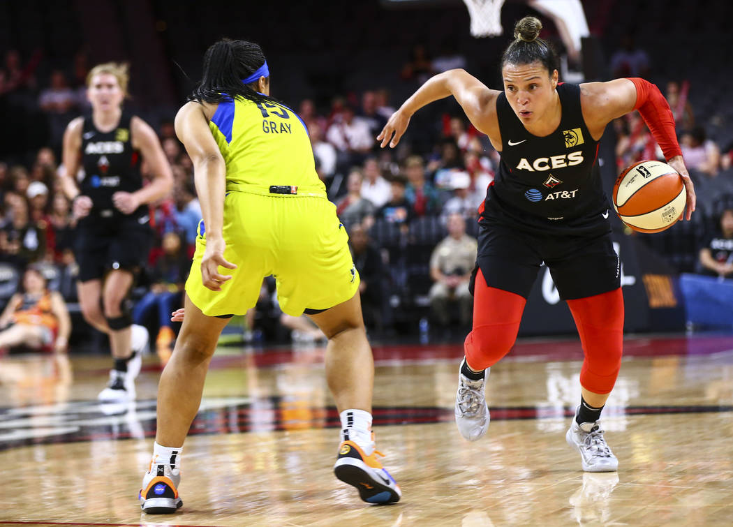 Las Vegas Aces' Kayla McBride drives to the basket against Dallas Wings' Allisha Gray (15) duri ...