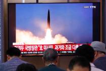People watch a TV showing a file image of North Korea's missile launch during a news program at ...