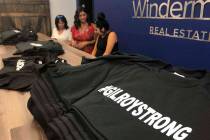 Employees and volunteers at Windermere Real Estate work at selling "#Gilroy Strong" T ...
