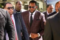 In a June 26, 2019, file photo, R&B singer R. Kelly, center, arrives at the Leighton Criminal C ...