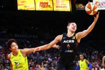 Las Vegas Aces' Dearica Hamby, right, gets a rebound in front of Dallas Wings' Isabelle Harriso ...