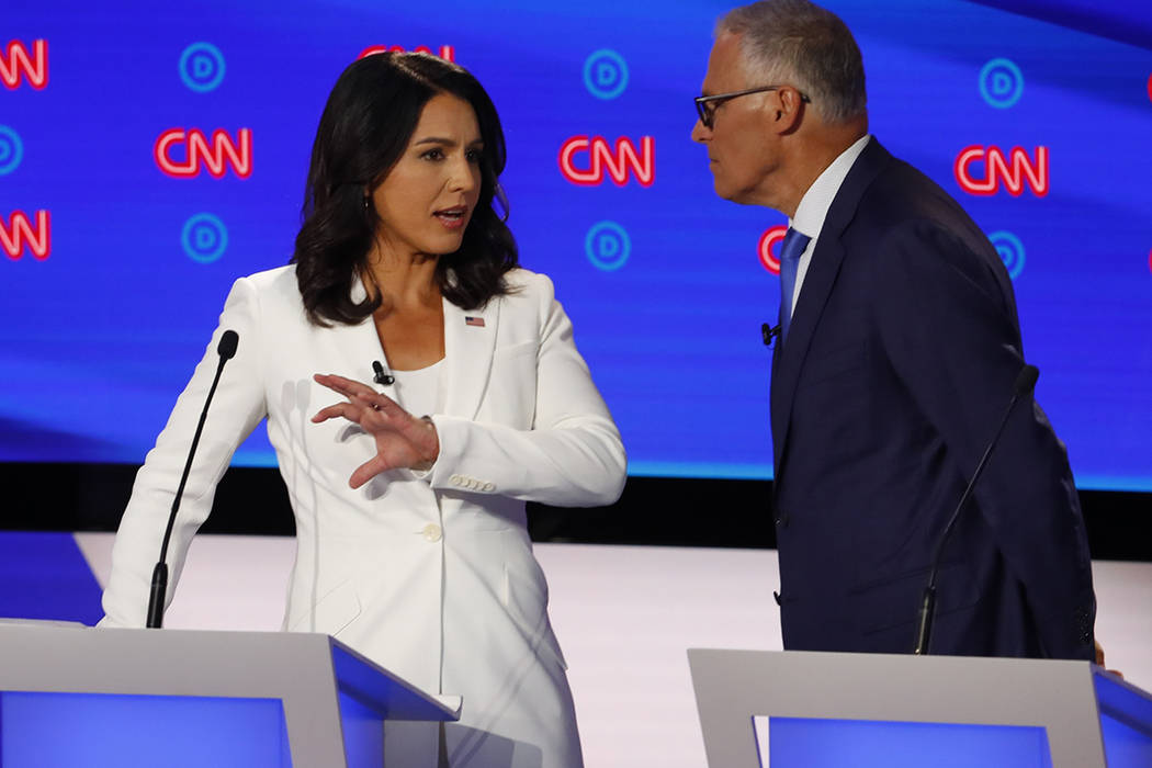 Rep. Tulsi Gabbard, D-Hawaii, and Washington Gov. Jay Inslee chat during a break in the second ...