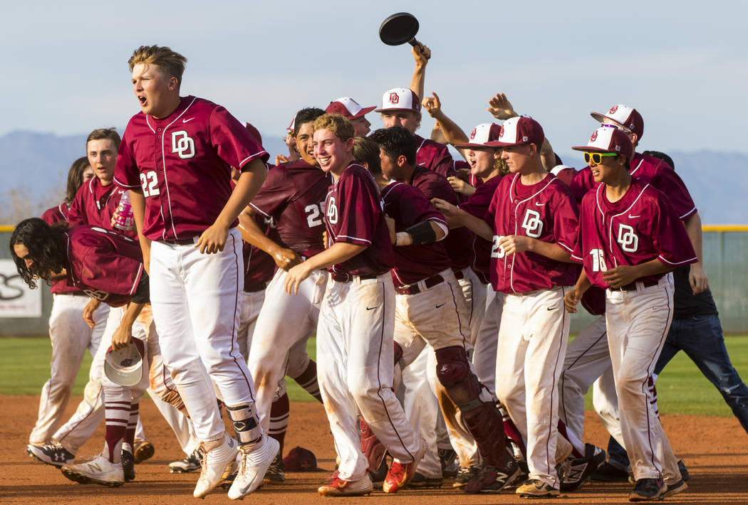 The Desert Oasis High School baseball team celebrates their win after the championship game ...