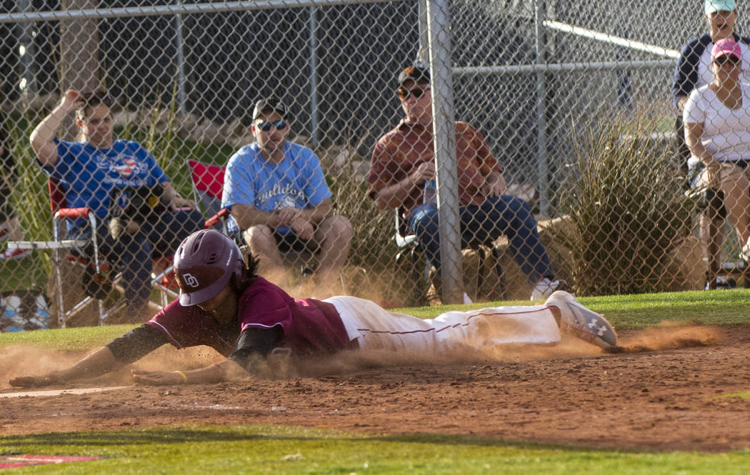 Desert Oasis infielder Andrew Martinez (2) slides into home base as the winning run during t ...