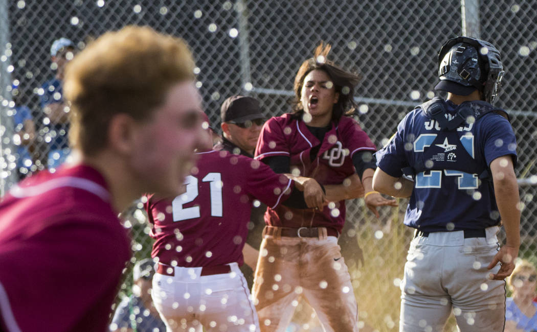 The Desert Oasis High School baseball team celebrates their win after the championship game ...