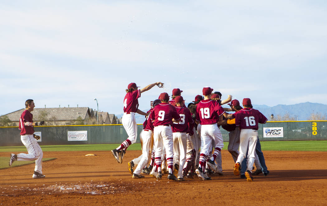 The Desert Oasis High School baseball team celebrates their win against Centennial High Scho ...